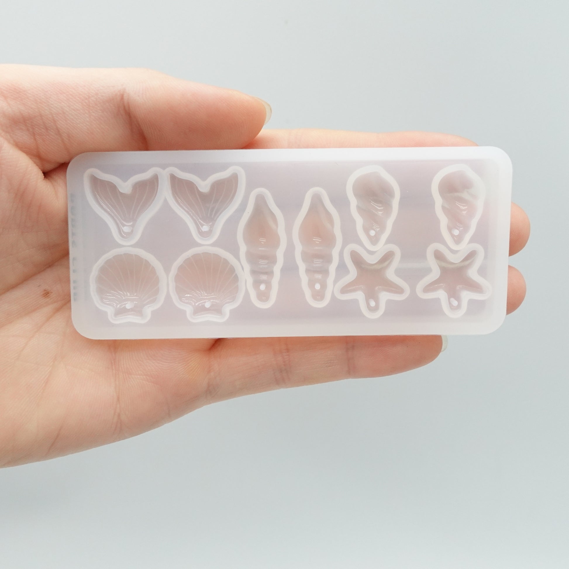 Premium marine resin mold featuring starfish, shell, and fin designs for UV resin jewelry making — by Onesika.